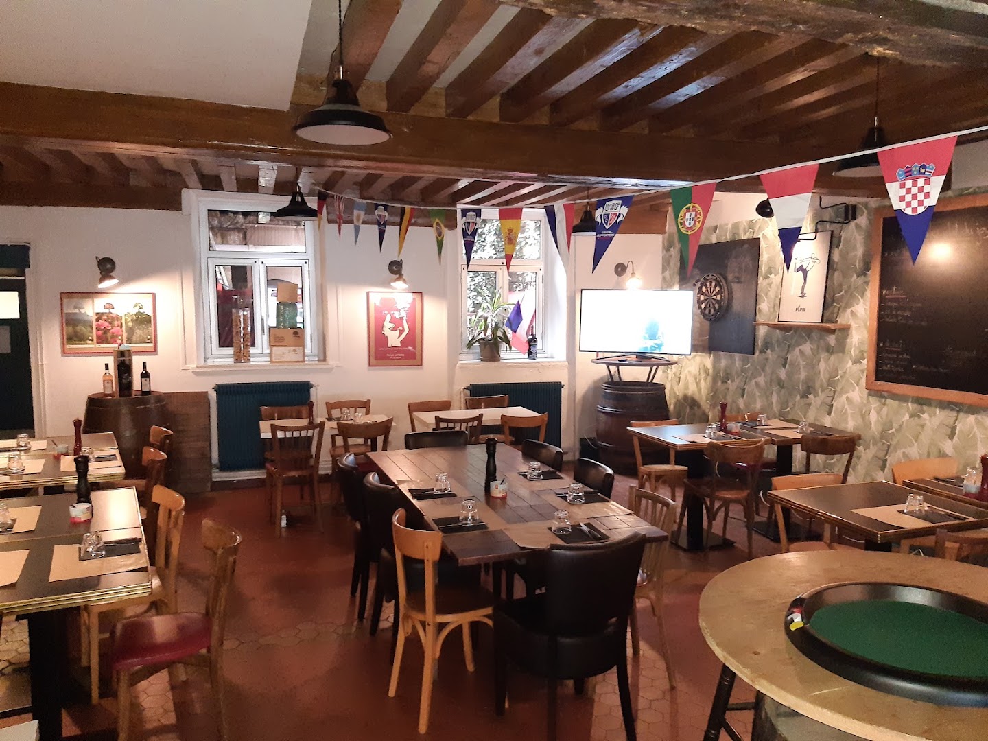 La salle vide du Café des Maka-B sous ses poutres en bois