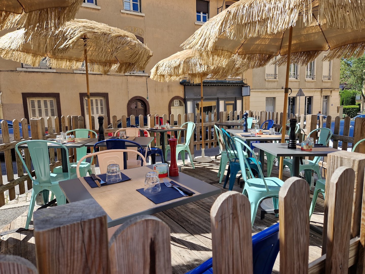 La terrasse colorée du café sous des parasols en paille